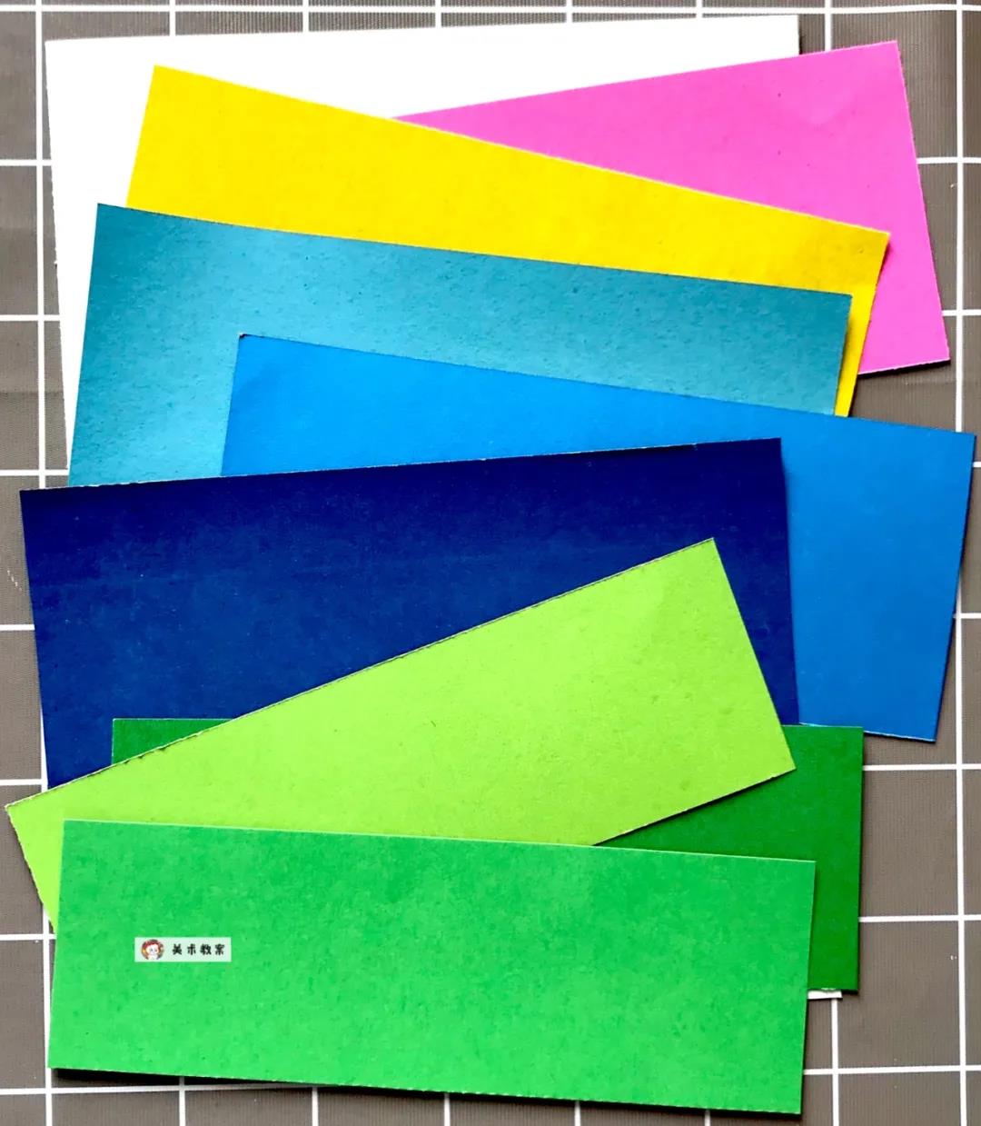 黄色,绿色系卡纸条剪成草丛,蓝色系卡纸条剪成水波,粉色不剪,贴成画面