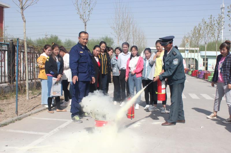 新民幼儿园教师在练习使用灭火器3.jpg